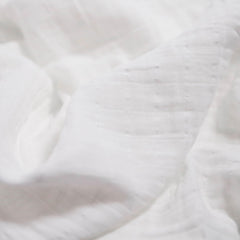 Little Unicorn muslin swaddle blanket white closeup shows gentle texture for baby skin.