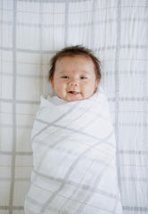 Little Unicorn swaddle grey plaid baby blanket unrolled for display of breathable fabric