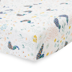 Little Unicorn premium crib sheet Peacock on mattress showcases breathable muslin for year-round comfort.