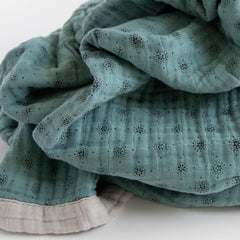Little Unicorn premium quilted throw serving as a car seat wrap for travel comfort.