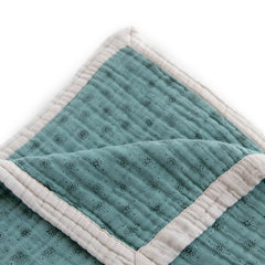 Little Unicorn premium quilted throw used as a stroller cover for on-the-go snuggles.
