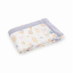 Little Unicorn Rainbows & Raindrops Deluxe Muslin Quilt on a crib scene emphasizes breathable fabric and comfort