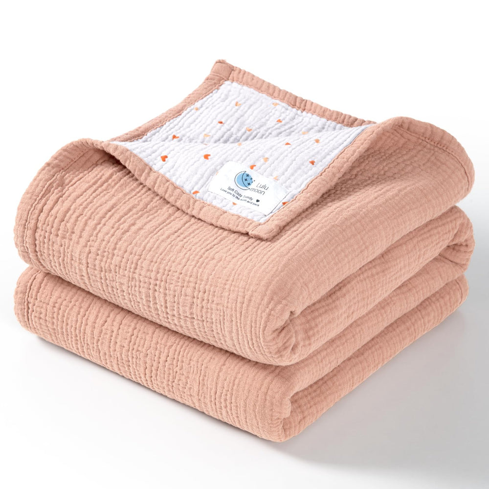 Lulumoon muslin blanket peach pink folded for cozy warmth.
