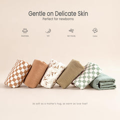 lulumoon muslin swaddle olive branches pattern photographed with nursery decor in soft neutral tones.