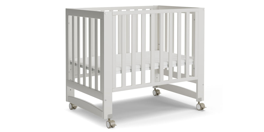 Mamazing EvoNest 6in1 crib in white with wheels for easy mobility.