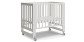 Mamazing EvoNest 6in1 crib in white with wheels for easy mobility.