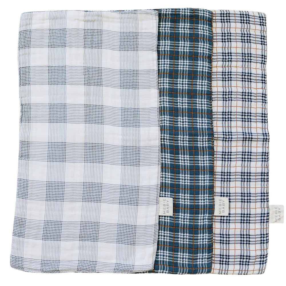 Mebie Baby burp cloth plaid muslin set shown in soft hues protecting outfits from spit-up.