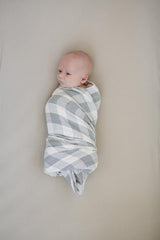 Mebie Baby Coastal Plaid Swaddle on a baby demonstrates a cozy, breathable wrap.