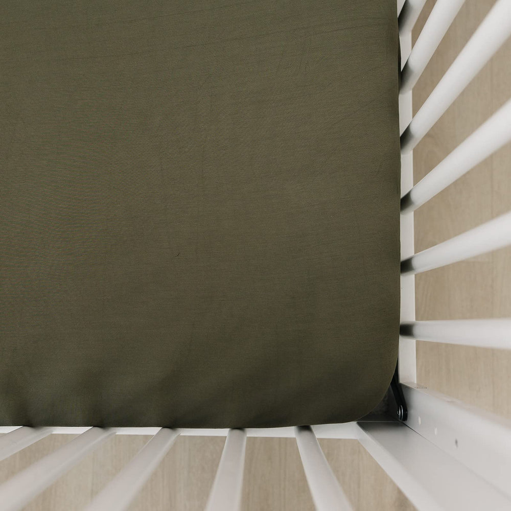 Mebie Baby stretch sheet olive on crib mattress for snug sleep fit.