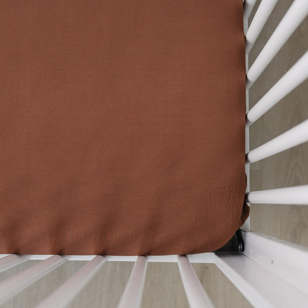 Mebie Baby stretch sheet rust close-up showing soft elastic fabric for a snug fit.