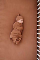 Mebie Baby stretch sheet rust flat lay highlights color versatility for nursery.