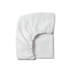 Meracorallo muslin crib sheet in white shows a snug, secure fit for standard cribs.