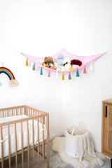 Mkono pink hammock displays plush toys on wall