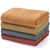 Momcozy muslin swaddle close-up shows soft breathable fabric for newborns