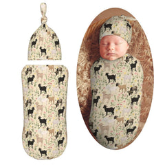 Muishi goats and flowers swaddle blanket in a cozy newborn setup for peaceful sleep