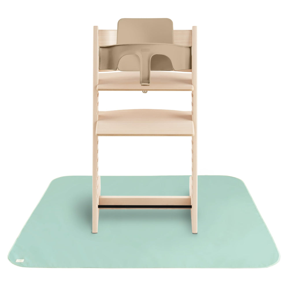 Mushie splat mat under high chair for clean mealtimes.