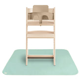 Mushie splat mat under high chair for clean mealtimes.