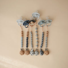 Mushie Eva two-tone beads offer a gentle grip on the pacifier.