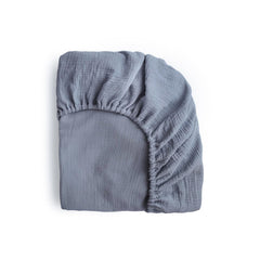 Mushie extra soft muslin mini sheet in Tradewinds folded for a snug night