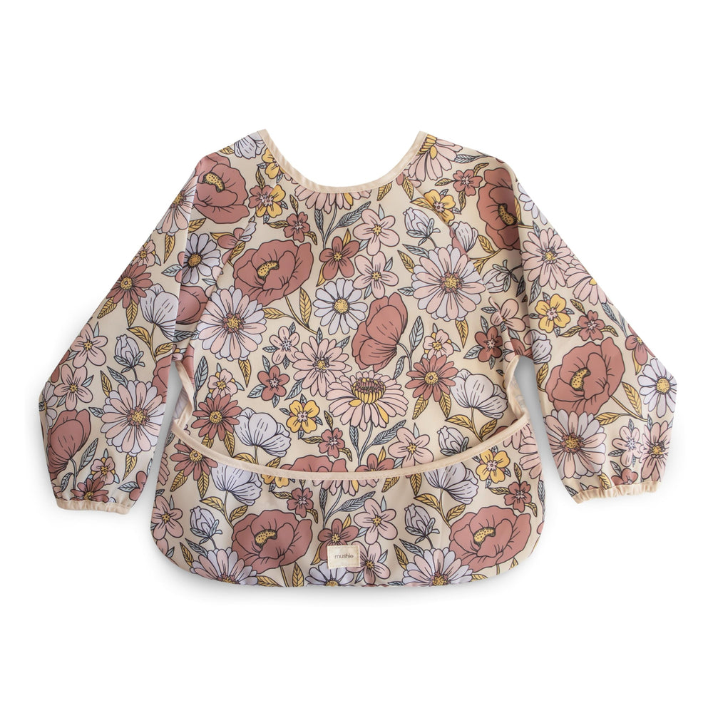 Mushie long sleeve bib retro flowers front view catching crumbs during meals