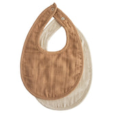 Mushie muslin bib with adjustable snaps in tan keeps teething baby dry.