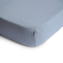 Mushie muslin fitted mini crib sheet Tradewinds shows elastic edges for secure fit