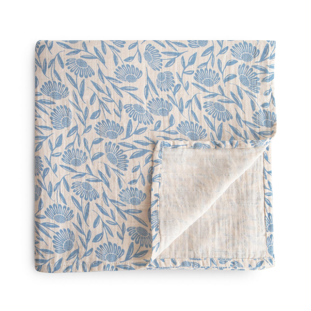 Mushie Muslin Swaddle Blanket blue flowers soft texture for newborn comfort.