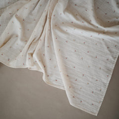 Mushie muslin swaddle blanket in nursery scene demonstrates breathable fabric for cozy naps
