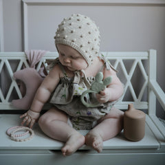 Close-up of Mushie Pearl Teether Bracelet texture, smooth silicone ready for teething.