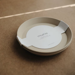 Mushie round dinnerware vanilla plate close-up, smooth surface ideal for quick cleanup.