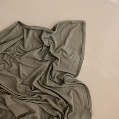 Flat view of 47x47 inch Mushie swaddle demonstrating generous size.
