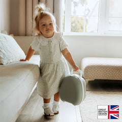 My Carry Potty hangs from a pushchair, illustrating convenient portability on trips.