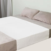 OUTCREATOR Saddle Style Bed Pad on bed showing tuck-in fit for secure protection.