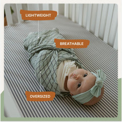 Parker Baby Co sage swaddle shown as stroller cover during a sunny outing