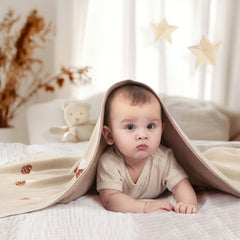 Pinuotu Mushroom Blanket swaddle-ready in cozy newborn setup.