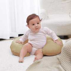 QUENESS nursing pillow surface showing baby seated with support.
