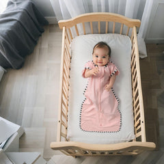 QUENESS Transition Swaddle baby sleeping peacefully in soft cotton fabric.