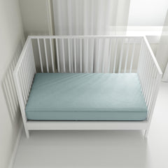 QuickZip crib sheet in dusty blue on mattress demonstrates secure fit and easy maintenance