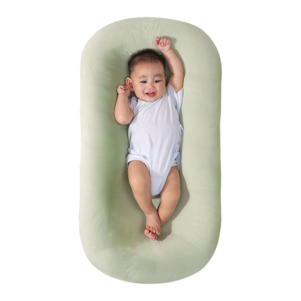 Saanerueen baby lounger in green cover provides cozy newborn support at home.