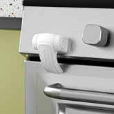SAFELON oven lock shown with adhesive installation securing the oven door.