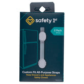Safety 1st Custom Fit strap secured to cabinet with adhesive for childproofing.