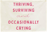 Sioial Thriving Surviving beige banner; easy to hang above crib.