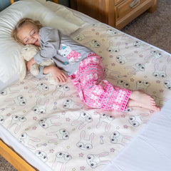 Snugglekid tuckable side bed pad with pink bunny print protects mattress during potty training nights.