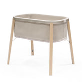 Stokke Snoozi Bassinet front view in sandy beige, safe sleep surface.