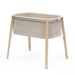 Stokke Snoozi Bassinet front view in sandy beige, safe sleep surface.
