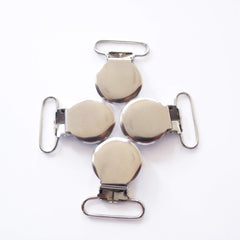 Sutoyuen pacifier clip silver 1in close-up with plastic teeth protecting fabric.