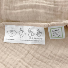SwaddleDesigns oatmeal blanket edge features 123-swaddle-label for easy steps.