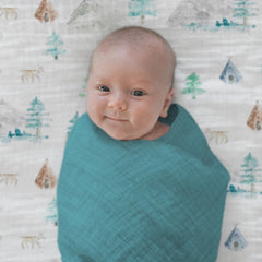 SwaddleDesigns teal muslin blanket laid as tummy time play mat