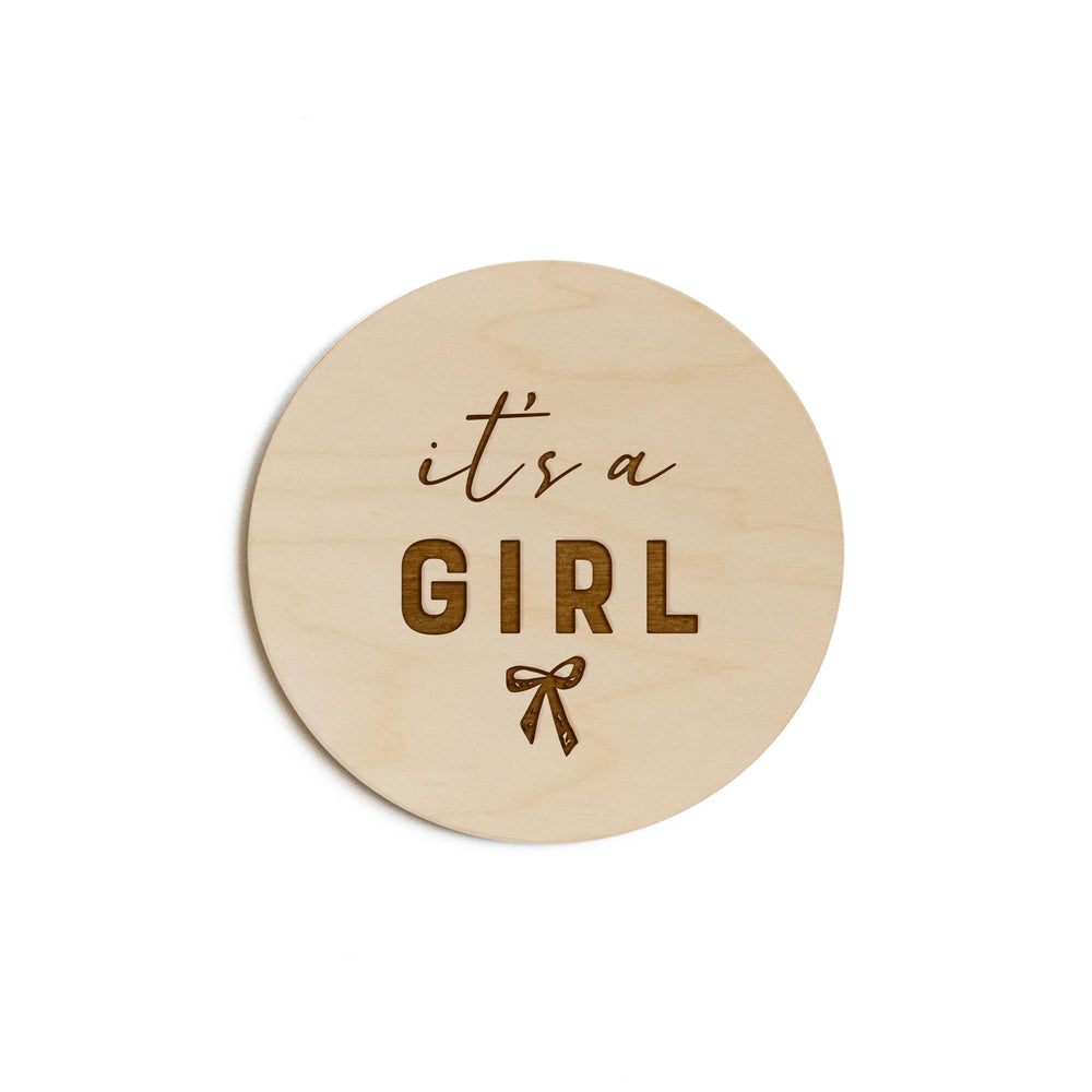 The Cotton & Canvas Co. It's a Girl with Bow disc, engraved for nursery keepsake.