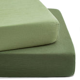 TILLYOU forest green muslin crib sheet on a standard crib mattress, soft and breathable